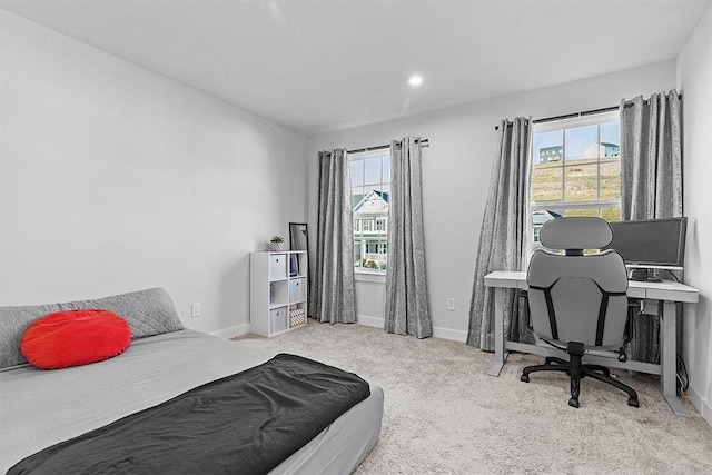 bedroom featuring light colored carpet and multiple windows