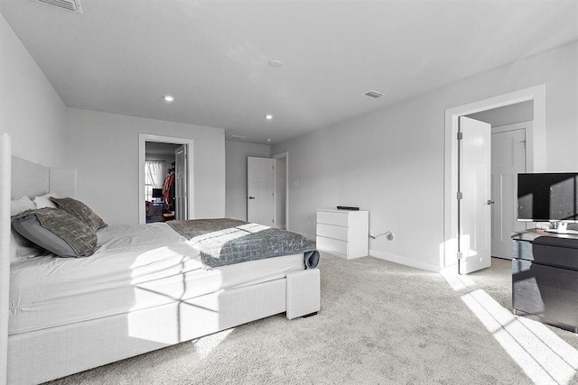 bedroom featuring a spacious closet, a closet, and light carpet