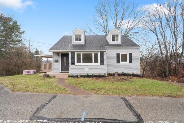 cape cod-style house featuring a front lawn