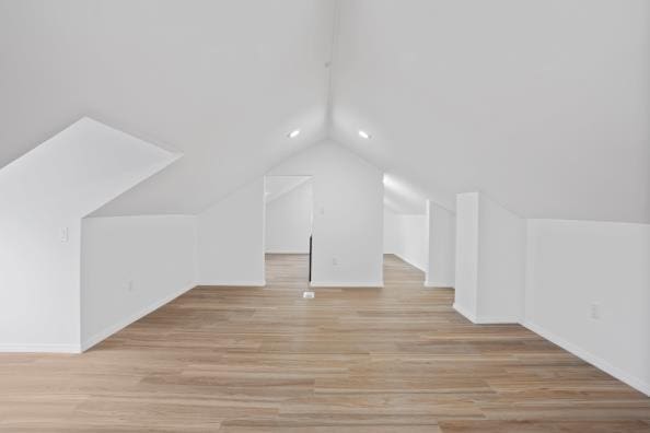 bonus room with lofted ceiling and light hardwood / wood-style flooring