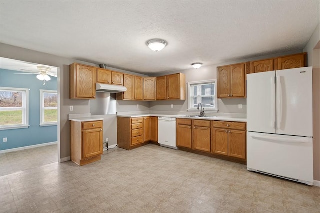 kitchen featuring a textured ceiling, a wealth of natural light, sink, and white appliances