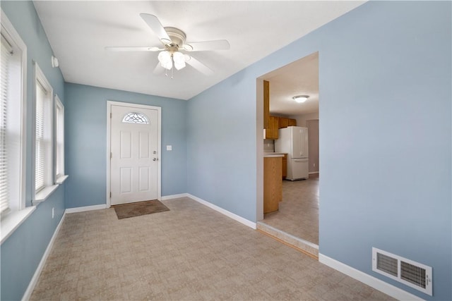 carpeted foyer entrance featuring ceiling fan