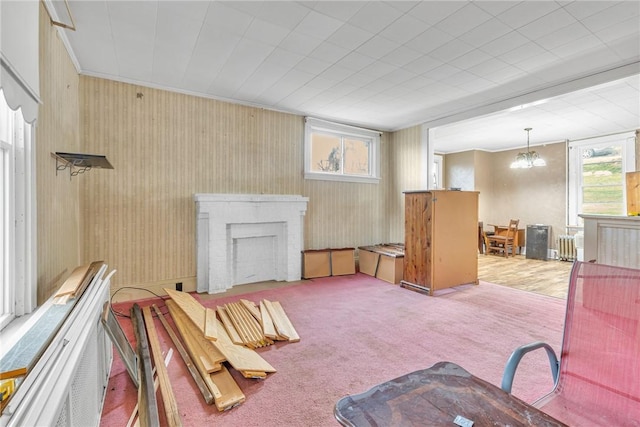 living room featuring carpet, plenty of natural light, crown molding, and a fireplace