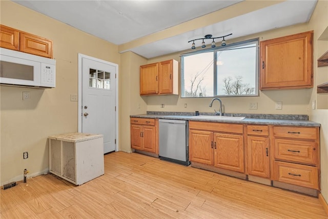 kitchen with stainless steel dishwasher, sink, and light hardwood / wood-style flooring