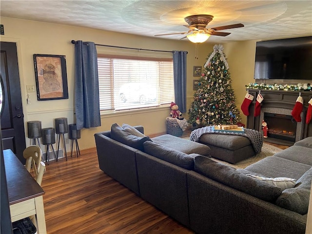 living room with dark hardwood / wood-style floors, ceiling fan, and a textured ceiling