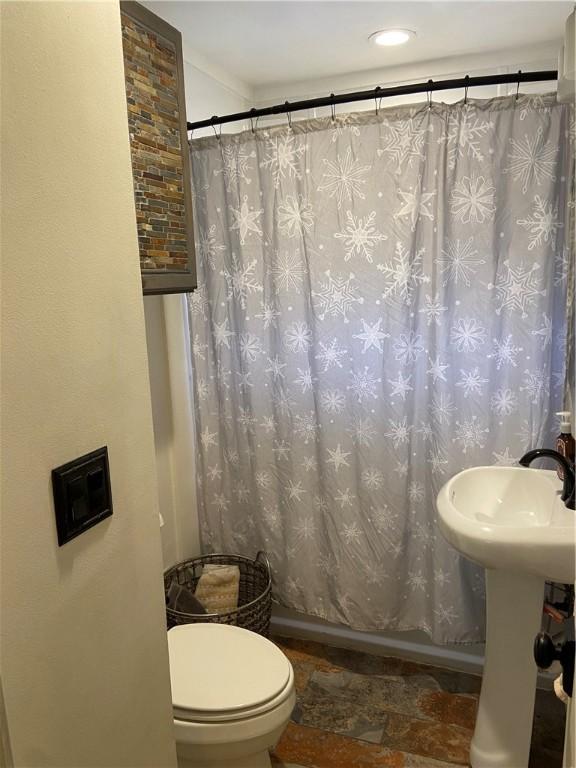 bathroom featuring a shower with curtain and toilet