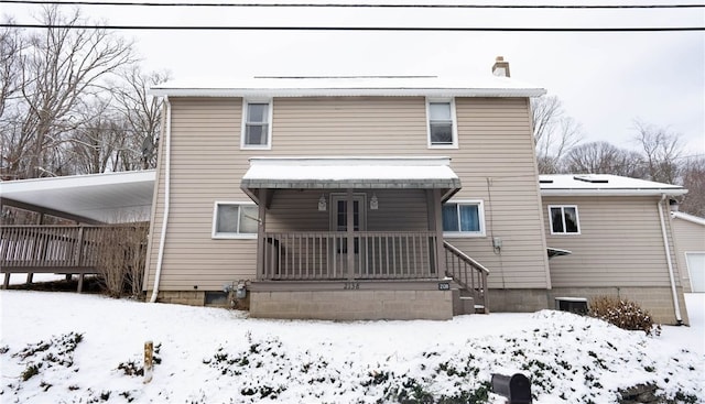 view of snow covered back of property