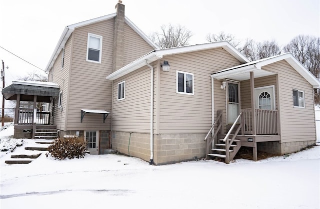 view of snow covered back of property