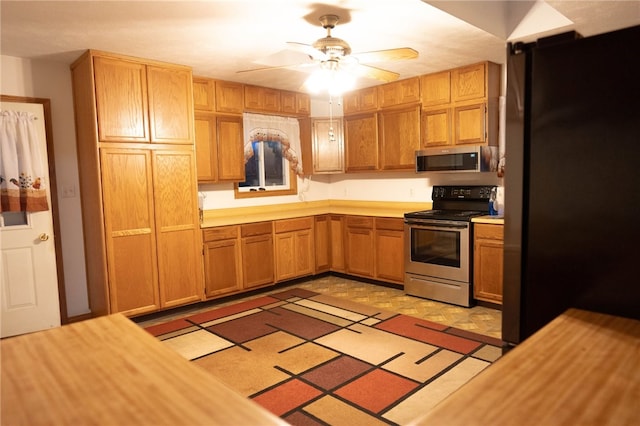 kitchen featuring butcher block countertops, ceiling fan, and appliances with stainless steel finishes