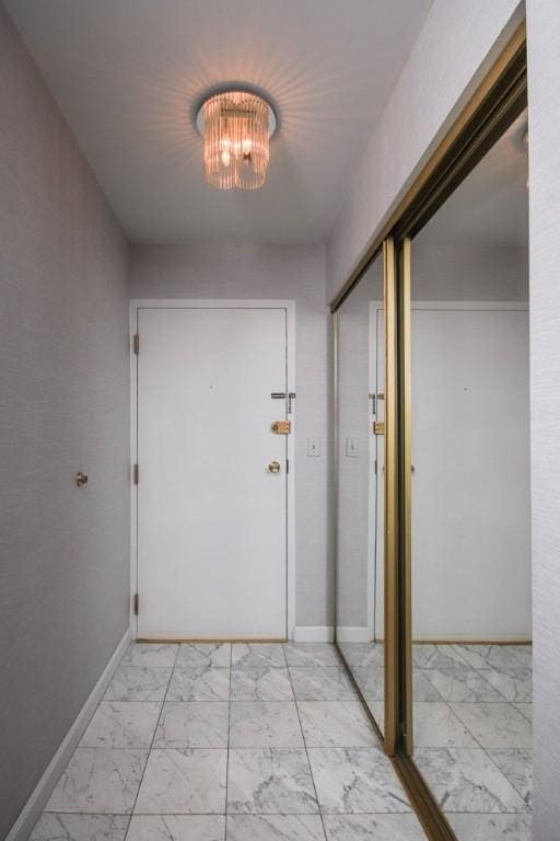 doorway featuring marble finish floor and baseboards