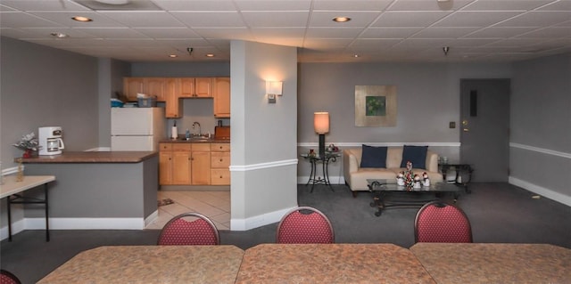 dining space with a paneled ceiling and baseboards