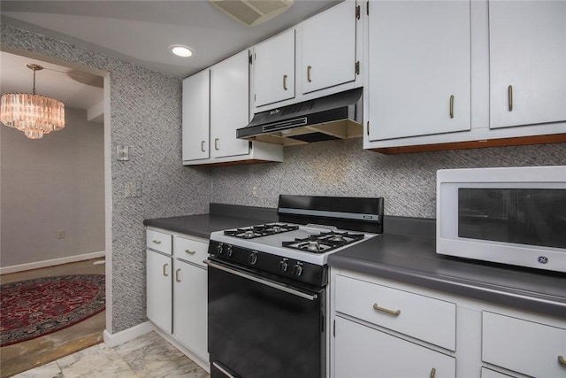 kitchen featuring dark countertops, gas range, white microwave, under cabinet range hood, and white cabinetry