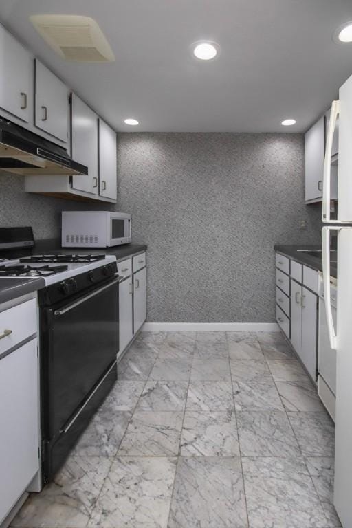 kitchen featuring black gas range, white cabinets, dark countertops, white microwave, and under cabinet range hood