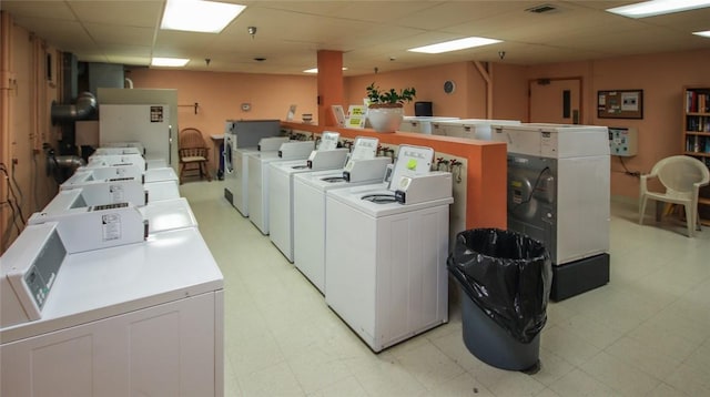 common laundry area with light floors, washing machine and clothes dryer, and visible vents