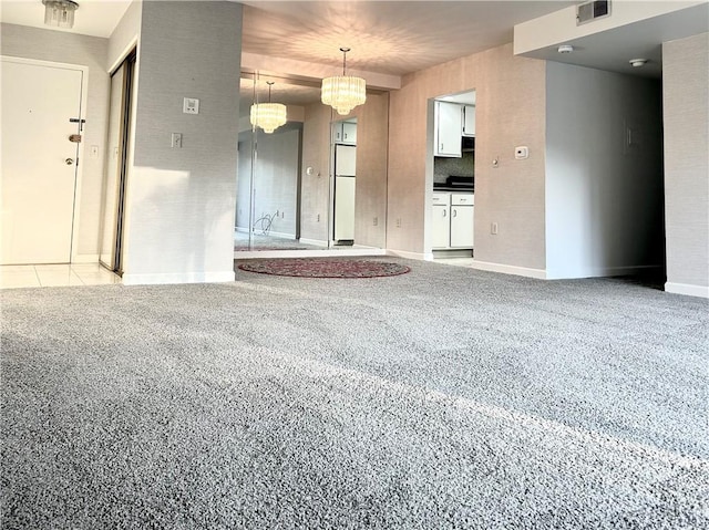 unfurnished room featuring a chandelier, baseboards, visible vents, and light colored carpet