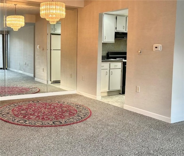 interior space with a chandelier, stove, white cabinetry, freestanding refrigerator, and decorative light fixtures