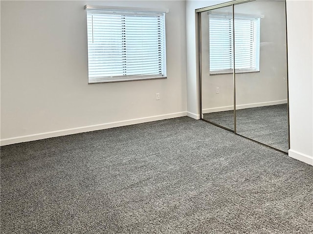 unfurnished bedroom with carpet floors, a closet, and baseboards