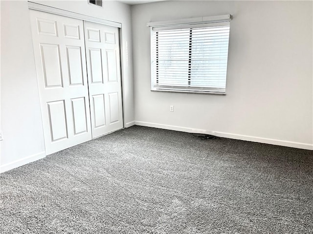 unfurnished bedroom featuring carpet floors, a closet, visible vents, and baseboards