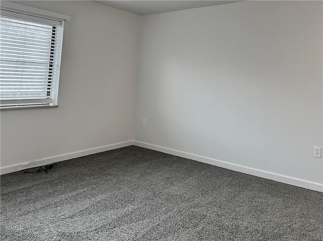 unfurnished room featuring carpet floors and baseboards