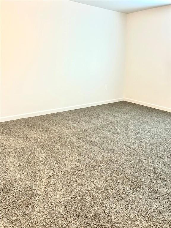 carpeted spare room with baseboards