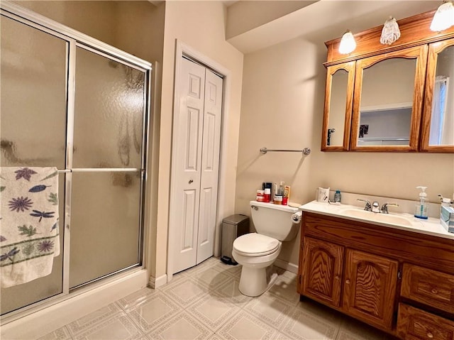 bathroom featuring vanity, toilet, and a shower with door