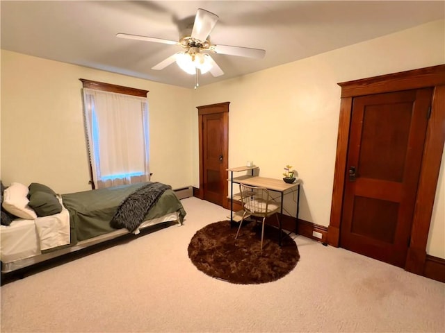 bedroom with baseboard heating, ceiling fan, and carpet