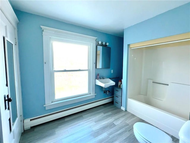 full bathroom featuring bathtub / shower combination, sink, toilet, a baseboard radiator, and wood-type flooring