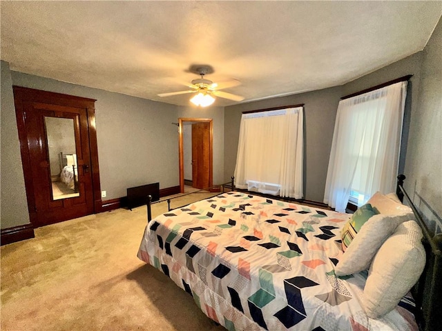 bedroom featuring ceiling fan and light carpet