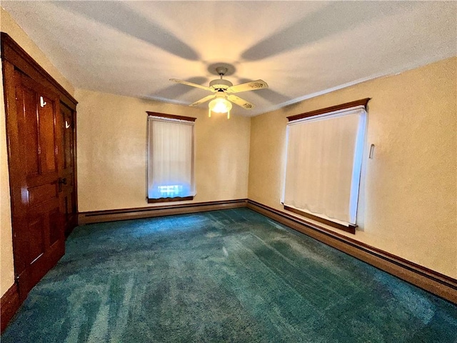 unfurnished bedroom featuring dark colored carpet, a textured ceiling, ceiling fan, and a baseboard heating unit