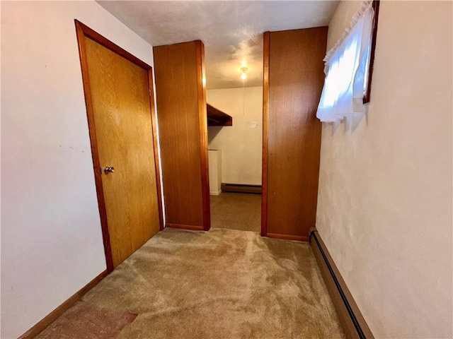 corridor featuring light colored carpet and a baseboard heating unit