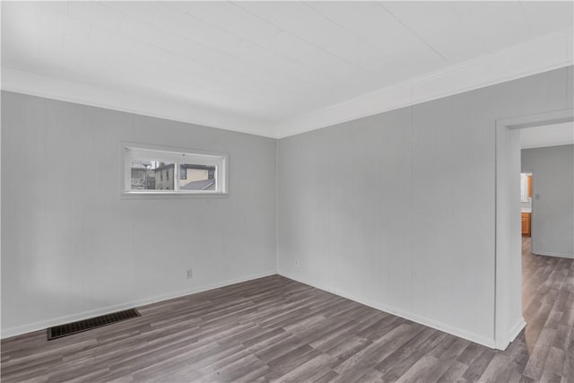 spare room featuring ornamental molding and hardwood / wood-style flooring