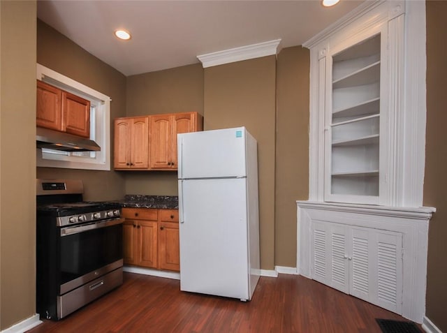 kitchen featuring dark wood-type flooring, stainless steel gas range oven, and white fridge