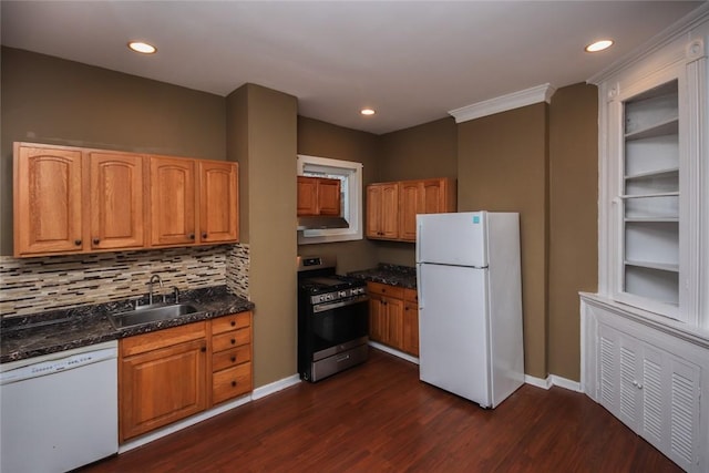 kitchen with sink, backsplash, dark hardwood / wood-style flooring, dark stone counters, and white appliances