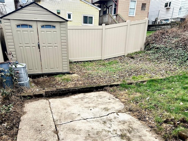 view of yard with central air condition unit and a storage unit