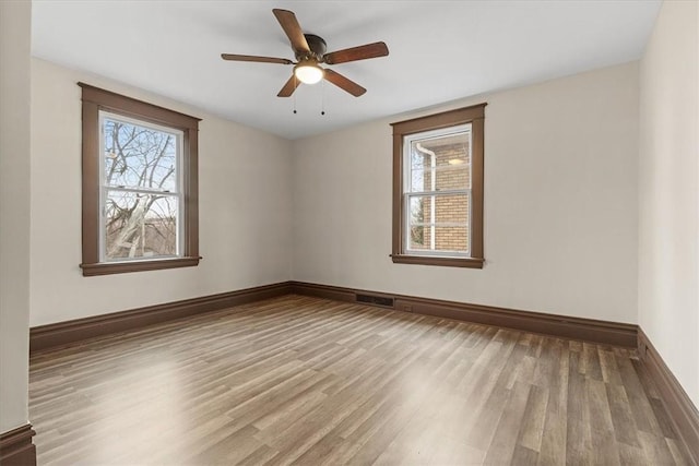 empty room with ceiling fan and light hardwood / wood-style flooring