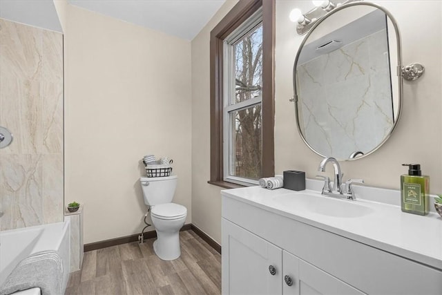 bathroom featuring a bathtub, hardwood / wood-style floors, vanity, and toilet