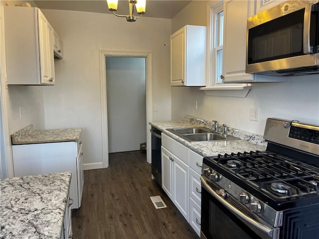 kitchen featuring white cabinets, dark hardwood / wood-style floors, appliances with stainless steel finishes, and a chandelier