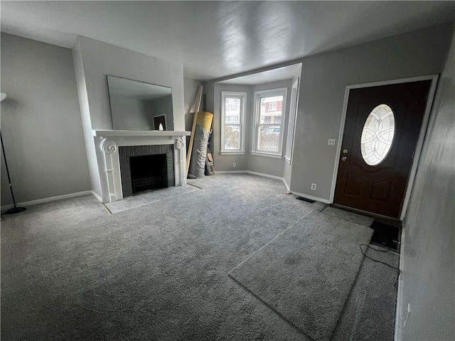 entrance foyer featuring light carpet and a fireplace