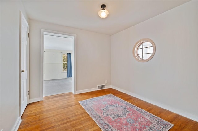 spare room featuring a healthy amount of sunlight and light wood-type flooring