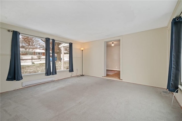 carpeted empty room featuring a baseboard radiator