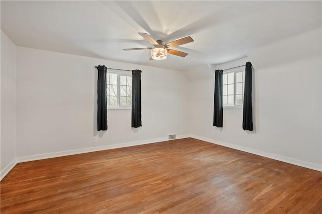 unfurnished room featuring ceiling fan, hardwood / wood-style floors, a healthy amount of sunlight, and lofted ceiling