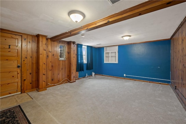 basement with ornamental molding, light colored carpet, and wooden walls