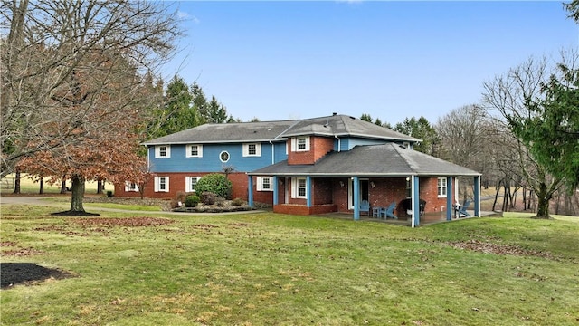 back of property featuring a lawn and a patio area