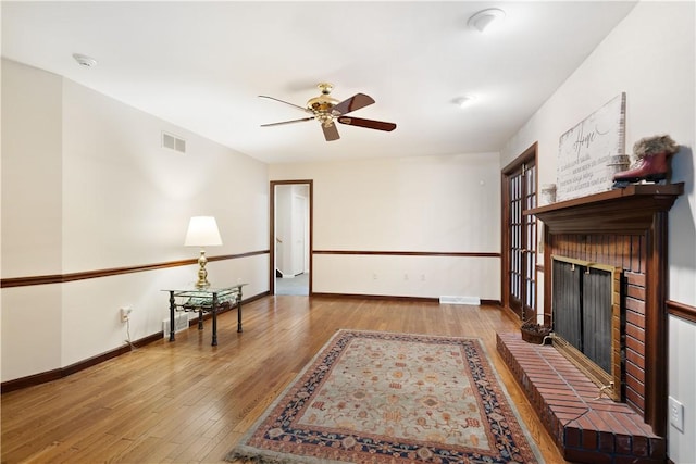 interior space featuring hardwood / wood-style floors, ceiling fan, and a fireplace