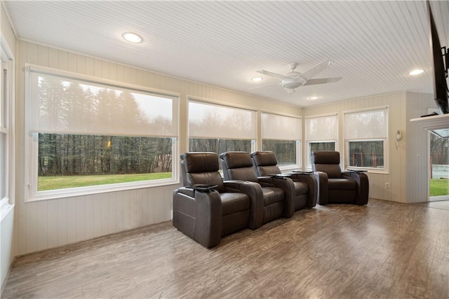 cinema room featuring ceiling fan, a healthy amount of sunlight, and light wood-type flooring