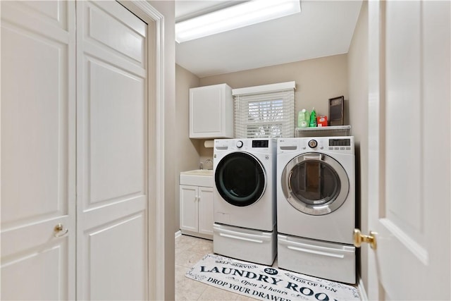 laundry room with washer and dryer, light tile patterned flooring, cabinets, and sink