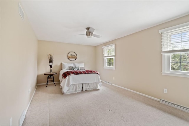 bedroom with light carpet, ceiling fan, and a baseboard heating unit