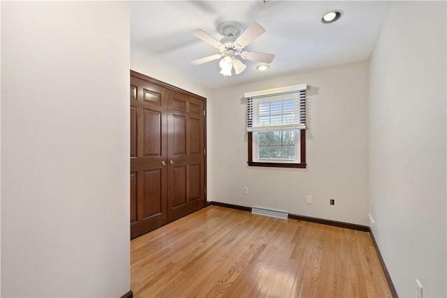 unfurnished bedroom with ceiling fan, a closet, and light wood-type flooring