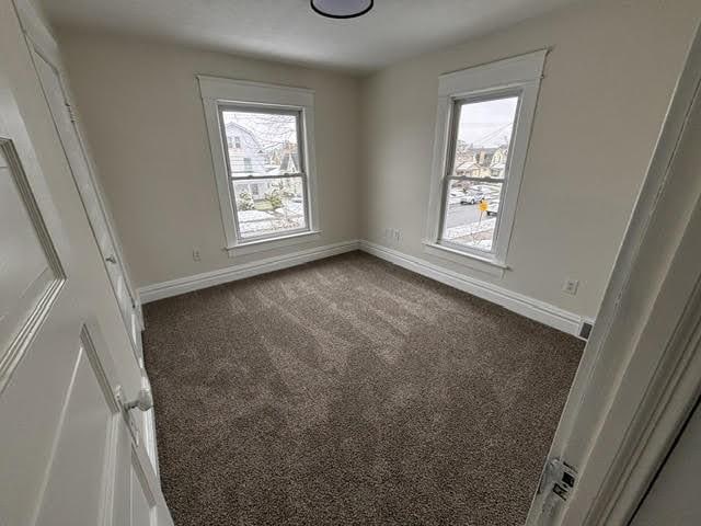 empty room featuring dark carpet