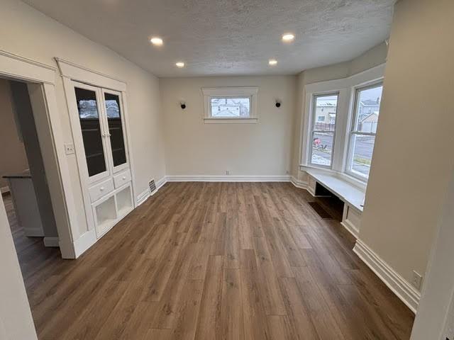 spare room with dark wood-type flooring and a textured ceiling